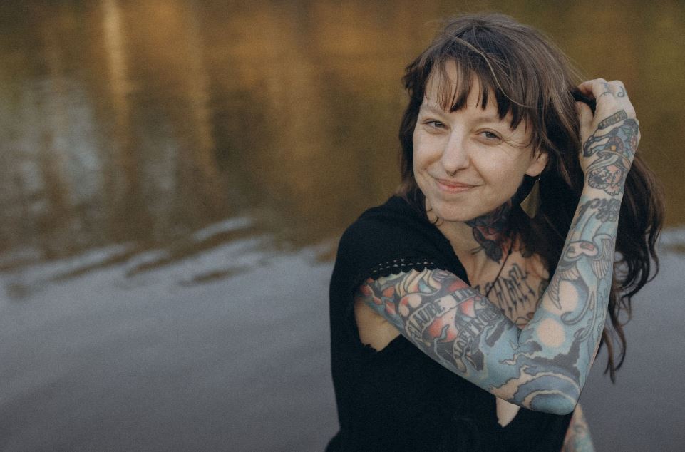 Angelina Katharina Petersen, steht im Wasser, lächelt und streicht sich durchs Haar