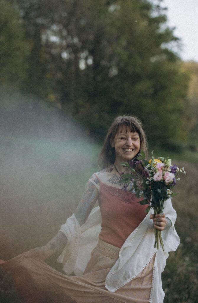 Angelina petersen tanz in der natur mit blumen und sonne. Sie begleitet menschen auf dem weg zu einem glücklichen lebengefühl