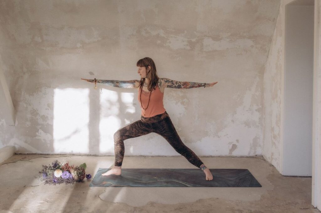 Angelina Katharina Petersen, steht im Asana Krieger zwei. Unterrichtet Yoga in Leipzig